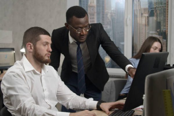 Medium shot of a young man giving explanations to his coworker in an office